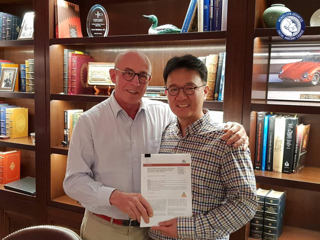 Dr. Min-Hee Ryu holding a printed copy of his paper published in Aesthetic Surgery Journal